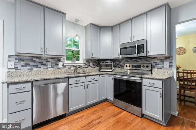 9380 Caucus Dr, King George, VA 22485 - kitchen with stainless steel appliances, a sink, gray cabinets, and light wood-type flooring