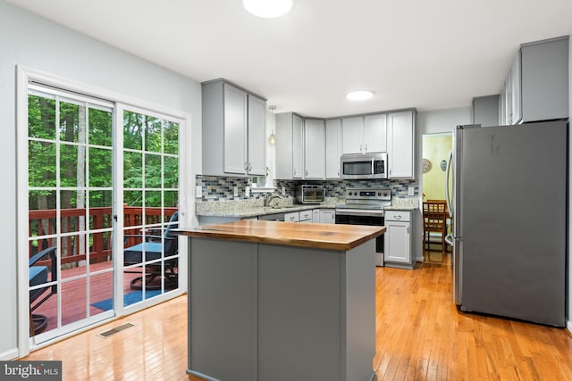 9380 Caucus Dr, King George, VA 22485 - kitchen with stainless steel appliances, gray cabinetry, backsplash, wood counters, and light wood-style floors