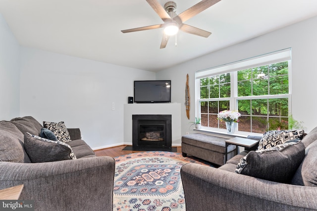 9380 Caucus Dr, King George, VA 22485 - living area with wood finished floors, ceiling fan, vaulted ceiling, a fireplace with flush hearth, and baseboards