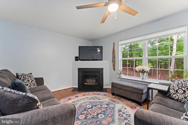 9380 Caucus Dr, King George, VA 22485 - living area featuring wood finished floors, vaulted ceiling, a fireplace with flush hearth, ceiling fan, and baseboards