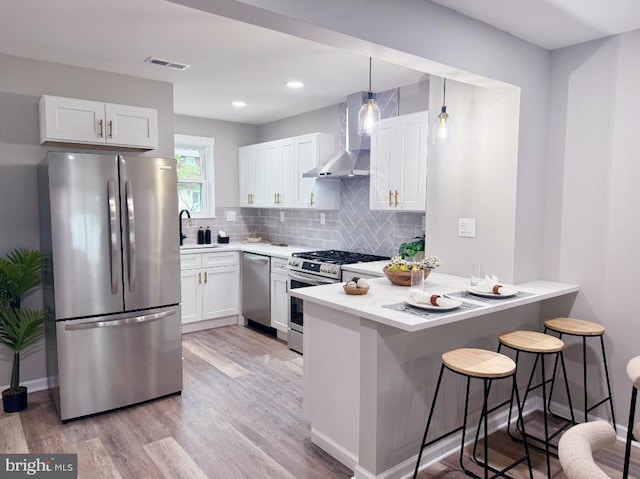 185 La Cascata, Clementon, NJ 08021 - kitchen featuring stainless steel appliances, wall chimney exhaust hood, a peninsula, light wood-style flooring, and recessed lighting