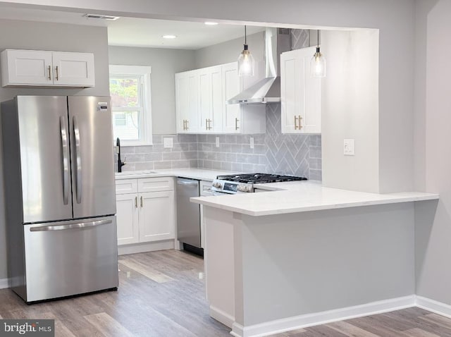 185 La Cascata, Clementon, NJ 08021 - kitchen with appliances with stainless steel finishes, wall chimney exhaust hood, light wood-type flooring, a sink, and a peninsula