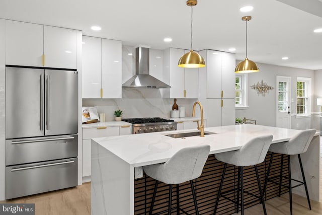 9813 Singleton Dr, Bethesda, MD 20817 - kitchen featuring appliances with stainless steel finishes, wall chimney range hood, a sink, white cabinets, and recessed lighting