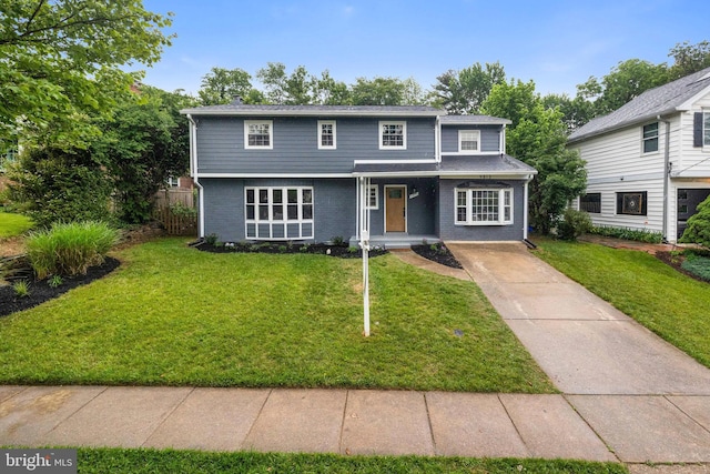 9813 Singleton Dr, Bethesda, MD 20817 - traditional home with a front yard, driveway, a porch, and brick siding