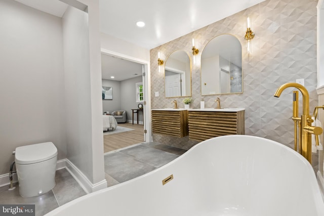 9813 Singleton Dr, Bethesda, MD 20817 - ensuite bathroom featuring a freestanding bath, double vanity, baseboards, and recessed lighting