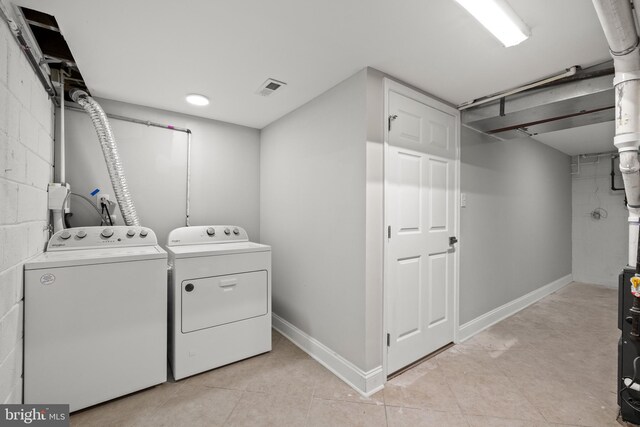 9813 Singleton Dr, Bethesda, MD 20817 - laundry room featuring washer and dryer, concrete block wall, light tile patterned floors, and baseboards