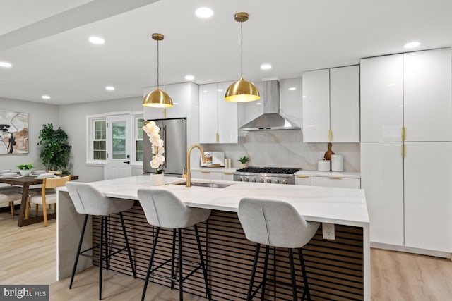 9813 Singleton Dr, Bethesda, MD 20817 - kitchen featuring wall chimney exhaust hood, a sink, stainless steel appliances, white cabinetry, and light wood-style floors
