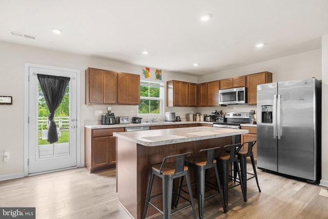 140 Mariners Way, Cambridge, MD 21613 - kitchen with stainless steel appliances, light wood-style floors, light countertops, a kitchen island, and a kitchen bar