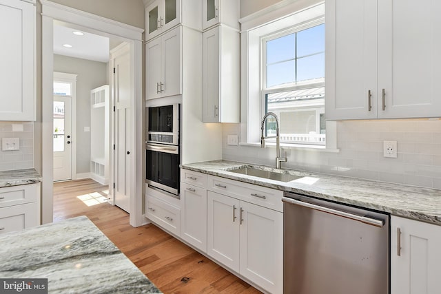 114 Jersey St, Dewey Beach, DE 19971 - kitchen with appliances with stainless steel finishes, a sink, white cabinetry, decorative backsplash, and light wood finished floors