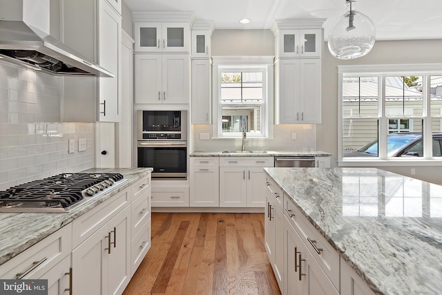 114 Jersey St, Dewey Beach, DE 19971 - kitchen with wall chimney range hood, appliances with stainless steel finishes, a sink, white cabinets, and recessed lighting