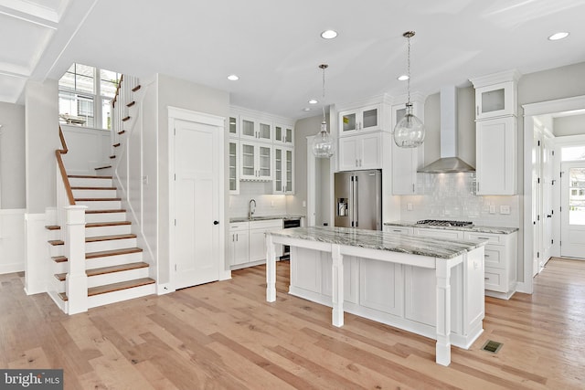 114 Jersey St, Dewey Beach, DE 19971 - kitchen featuring appliances with stainless steel finishes, wall chimney exhaust hood, a sink, a kitchen island, and decorative backsplash