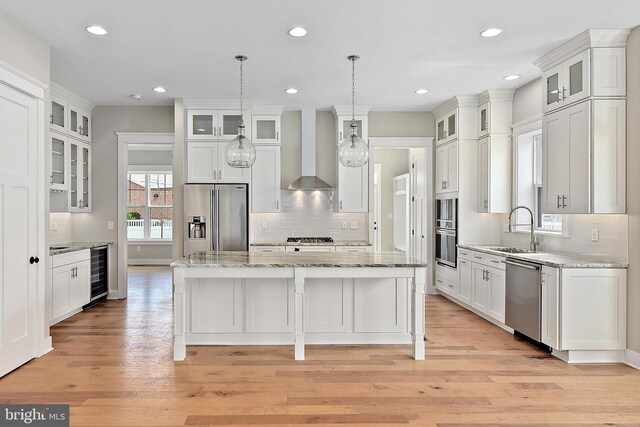 114 Jersey St, Dewey Beach, DE 19971 - kitchen featuring stainless steel appliances, wall chimney exhaust hood, beverage cooler, a sink, and decorative backsplash