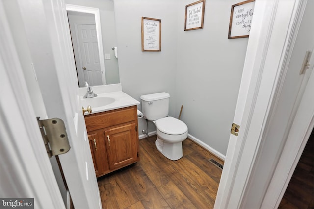 134 Cobblestone Dr, Gilbertsville, PA 19525 - half bathroom featuring vanity, toilet, wood finished floors, and baseboards