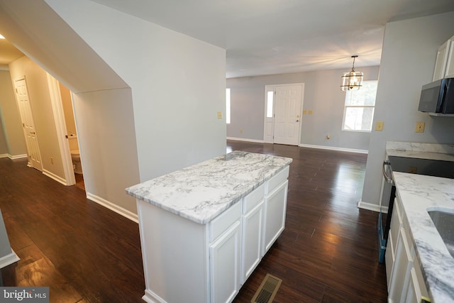 11699 Norris Twilley Rd, Sharptown, MD 21861 - kitchen featuring light stone countertops, baseboards, dark wood-type flooring, white cabinetry, and a center island