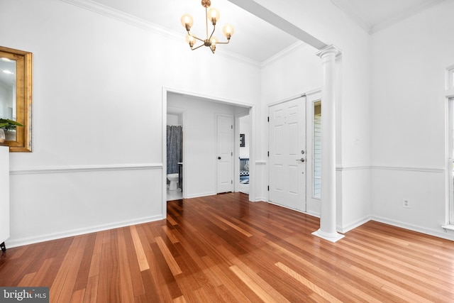 9177 Drawbridge Dr, Delmar, MD 21875 - foyer with ornate columns, a chandelier, wood finished floors, crown molding, and baseboards