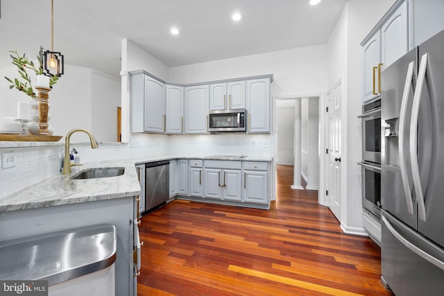 9177 Drawbridge Dr, Delmar, MD 21875 - kitchen featuring appliances with stainless steel finishes, a sink, dark wood finished floors, light stone counters, and decorative backsplash