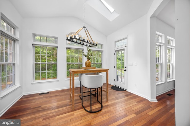 9177 Drawbridge Dr, Delmar, MD 21875 - dining room featuring a skylight, a chandelier, hardwood / wood-style floors, high vaulted ceiling, and baseboards