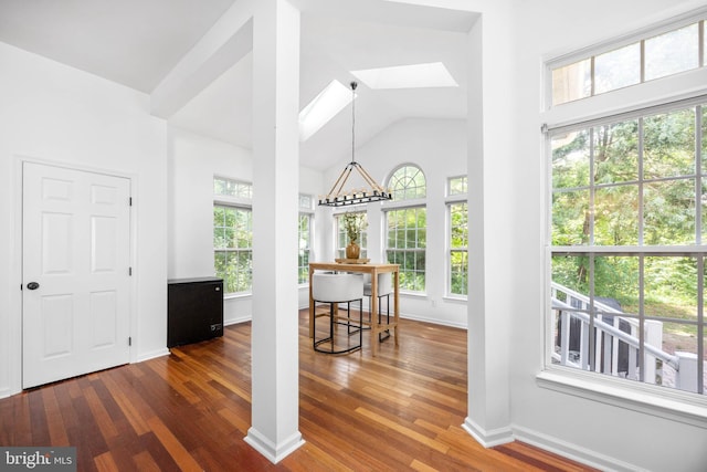 9177 Drawbridge Dr, Delmar, MD 21875 - dining space featuring a skylight, dark wood-style flooring, high vaulted ceiling, and baseboards