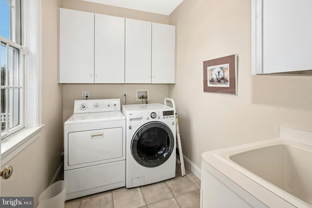 laundry room with cabinet space, washing machine and clothes dryer, baseboards, and light tile patterned flooring
