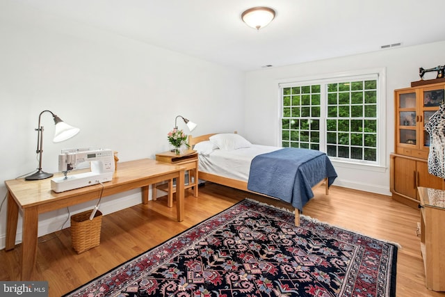 bedroom with light wood finished floors and baseboards
