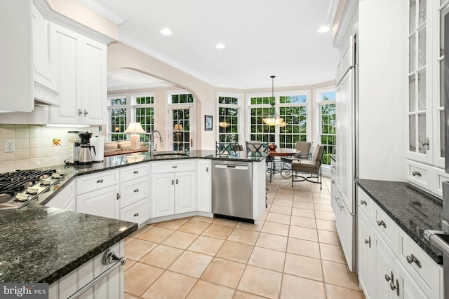 kitchen featuring appliances with stainless steel finishes, white cabinets, a peninsula, light tile patterned flooring, and healthy amount of natural light