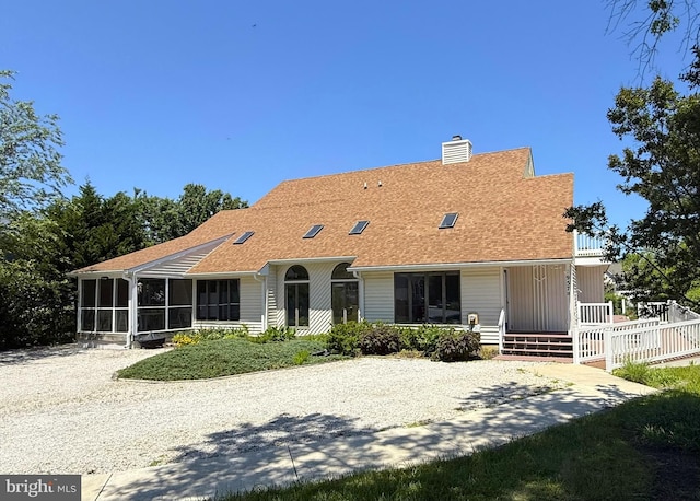 957 Terrapin St Unit 2, Bethany Beach, DE 19930 - rear view of house featuring a sunroom, a chimney, and roof with shingles