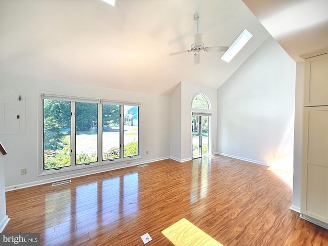 957 Terrapin St Unit 2, Bethany Beach, DE 19930 - unfurnished living room with a skylight, plenty of natural light, a ceiling fan, high vaulted ceiling, and light wood-style flooring