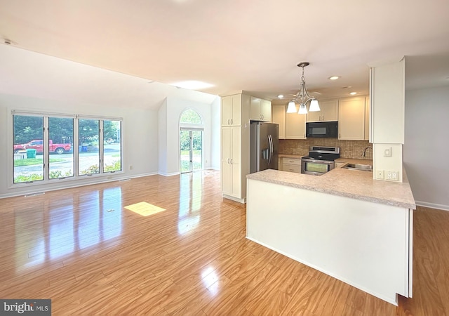 957 Terrapin St Unit 2, Bethany Beach, DE 19930 - kitchen with stainless steel appliances, a sink, light countertops, tasteful backsplash, and light wood-type flooring