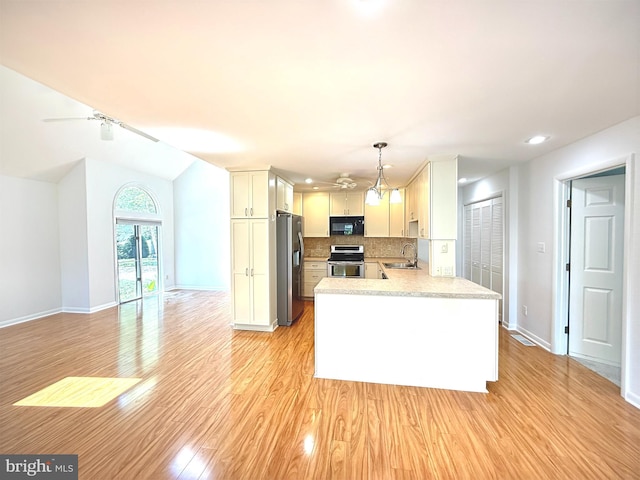 957 Terrapin St Unit 2, Bethany Beach, DE 19930 - kitchen featuring stainless steel appliances, a sink, light countertops, light wood finished floors, and backsplash