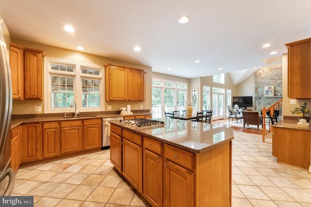 1296 Newkirk Ct, Vienna, VA 22182 - kitchen with stainless steel appliances, a center island, stone countertops, light tile patterned floors, and recessed lighting