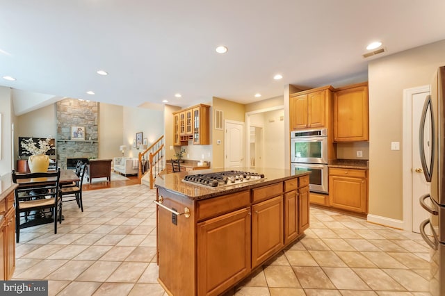 1296 Newkirk Ct, Vienna, VA 22182 - kitchen with appliances with stainless steel finishes, dark stone counters, light tile patterned floors, a fireplace, and recessed lighting