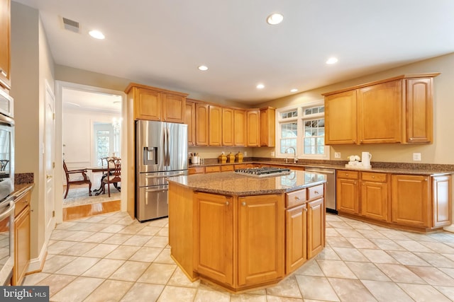 1296 Newkirk Ct, Vienna, VA 22182 - kitchen with appliances with stainless steel finishes, light stone counters, recessed lighting, light tile patterned floors, and a center island