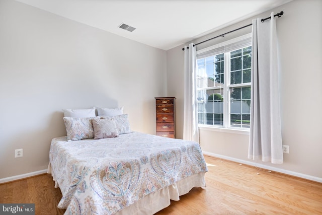bedroom with wood finished floors and baseboards