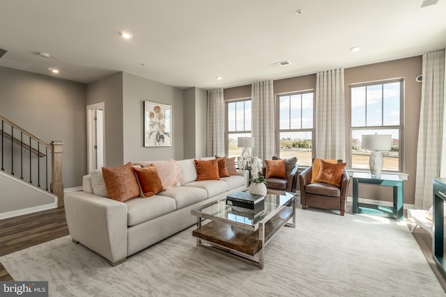 living room featuring wood finished floors, baseboards, stairway, and recessed lighting