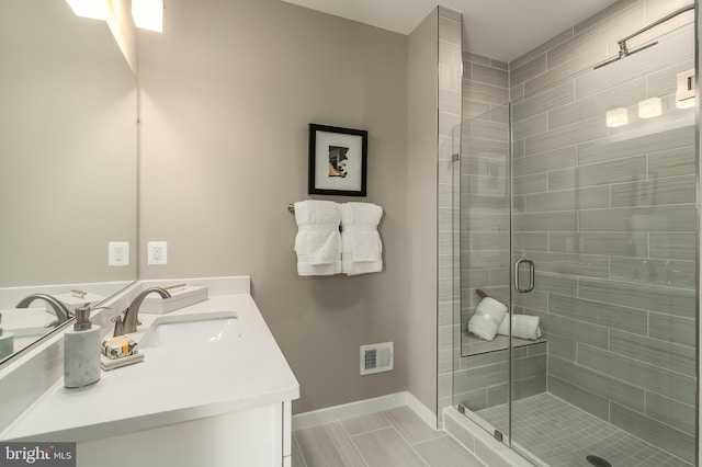 bathroom with a stall shower, baseboards, vanity, and tile patterned flooring