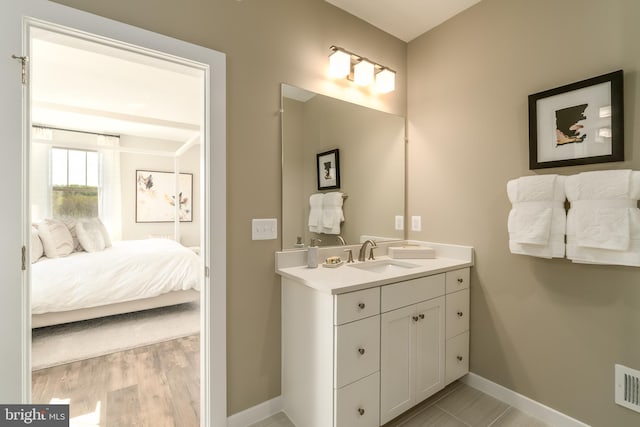 ensuite bathroom with baseboards and vanity