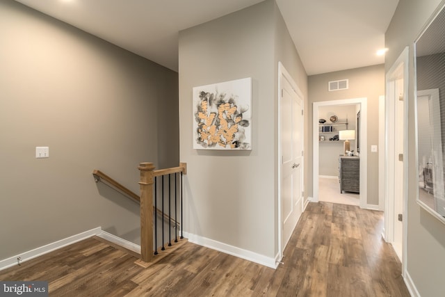 corridor featuring an upstairs landing, wood finished floors, baseboards, and recessed lighting