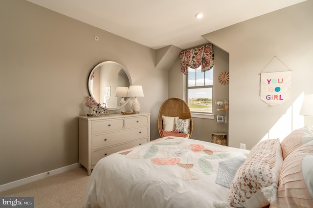 bedroom with light colored carpet and baseboards