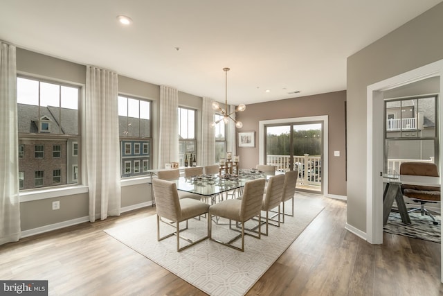 dining room with a chandelier, baseboards, plenty of natural light, light wood finished floors, and recessed lighting