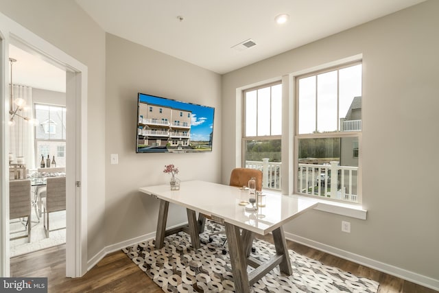 office space with baseboards, wood finished floors, and a chandelier