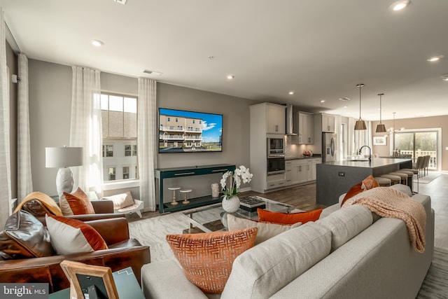 living room with wood finished floors, recessed lighting, and baseboards