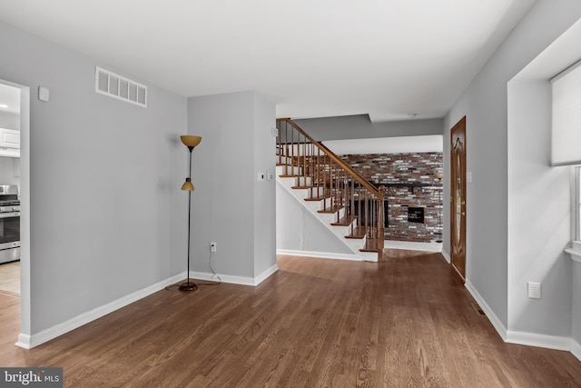 12 Constitution Rd, Clementon, NJ 08021 - unfurnished living room featuring wood finished floors, stairs, baseboards, and a fireplace