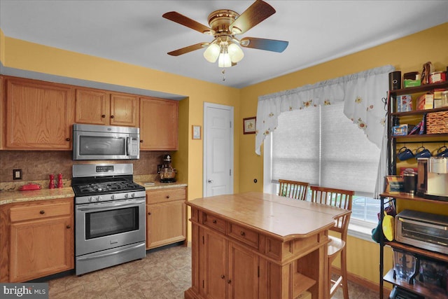3919 Penns Dr, Reading, PA 19606 - kitchen with appliances with stainless steel finishes, ceiling fan, light countertops, and decorative backsplash
