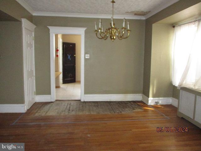 5322 N Carlisle St, Philadelphia, PA 19141 - unfurnished dining area with a chandelier, wood finished floors, ornamental molding, and baseboards
