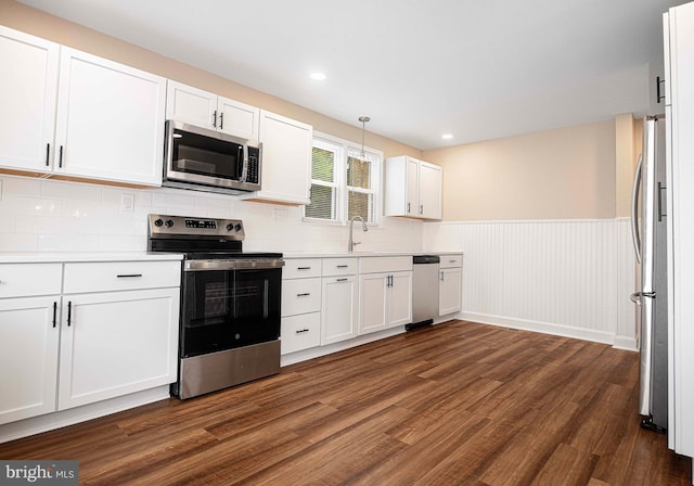 803 Essex Ave, Essex, MD 21221 - kitchen with appliances with stainless steel finishes, dark wood-style flooring, white cabinetry, wainscoting, and light countertops