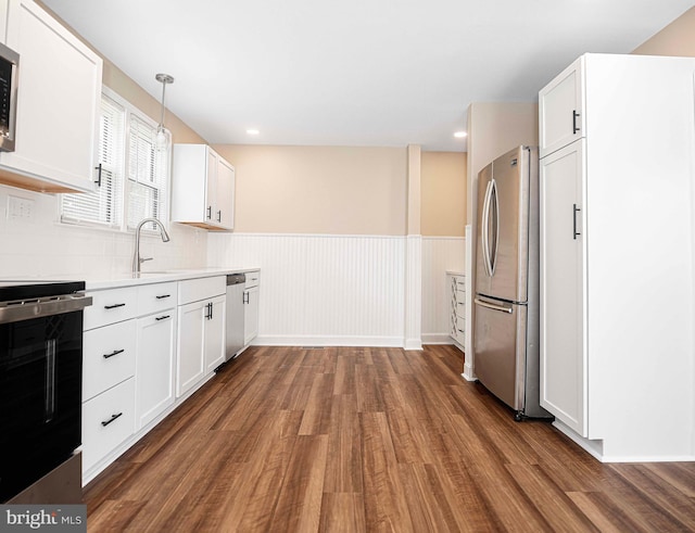 803 Essex Ave, Essex, MD 21221 - kitchen featuring stainless steel appliances, dark wood-type flooring, a sink, white cabinetry, and a wainscoted wall