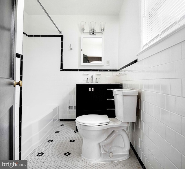 803 Essex Ave, Essex, MD 21221 - bathroom with tile walls, toilet, washtub / shower combination, vanity, and tile patterned flooring