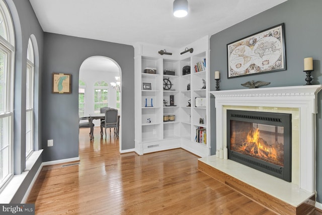 310 Owings Hill Ct, Owings, MD 20736 - living area with a glass covered fireplace, wood finished floors, arched walkways, and baseboards