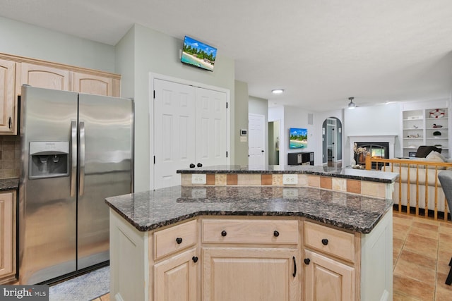 310 Owings Hill Ct, Owings, MD 20736 - kitchen featuring stainless steel refrigerator with ice dispenser, light brown cabinetry, a center island, open floor plan, and a glass covered fireplace