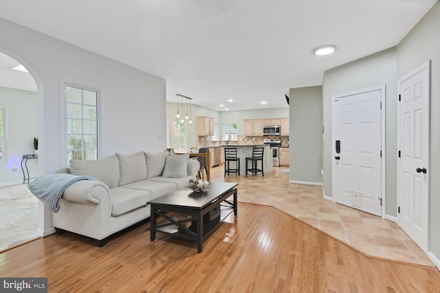 310 Owings Hill Ct, Owings, MD 20736 - living area with arched walkways, baseboards, and light wood finished floors